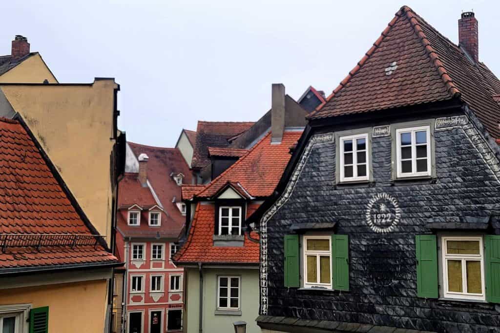 Interesting and intricate rooflines, with dormered windows and colored exteriors in green, pink, grey, and white