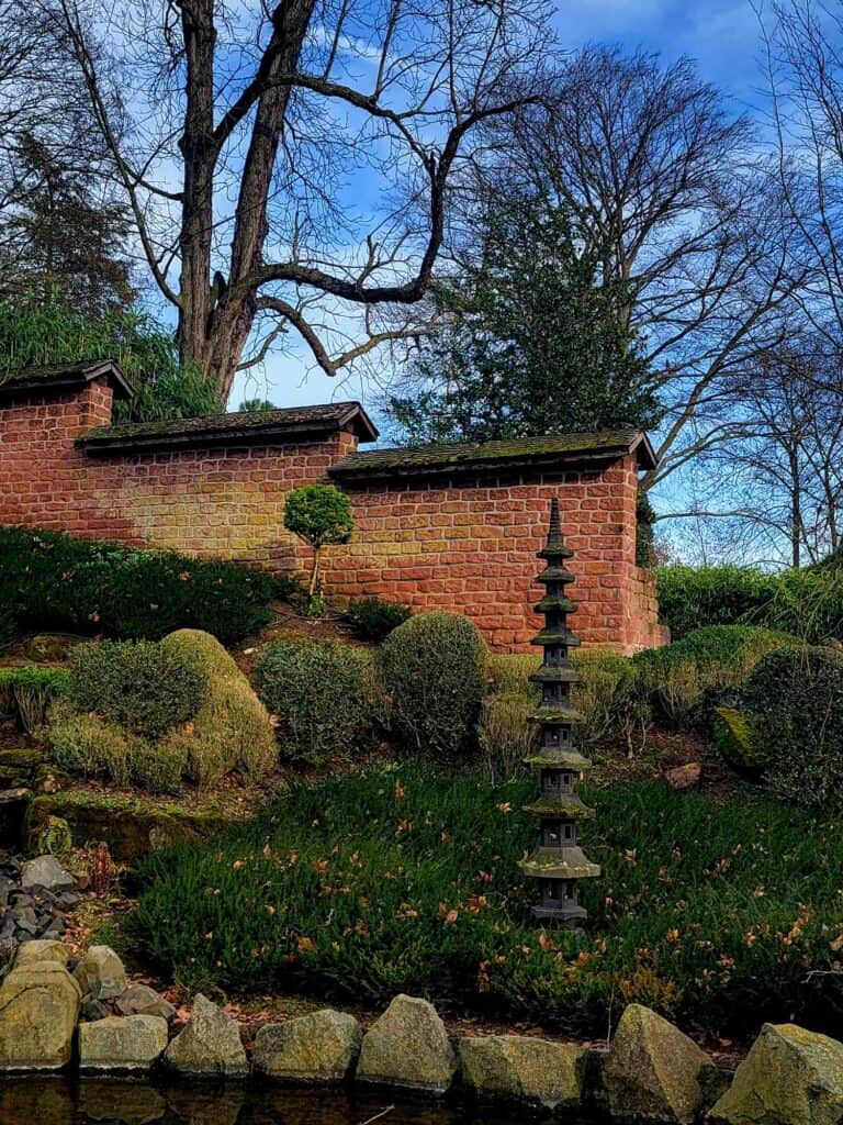 A pagoda behind a wall of stones with a brick tiered wall behind