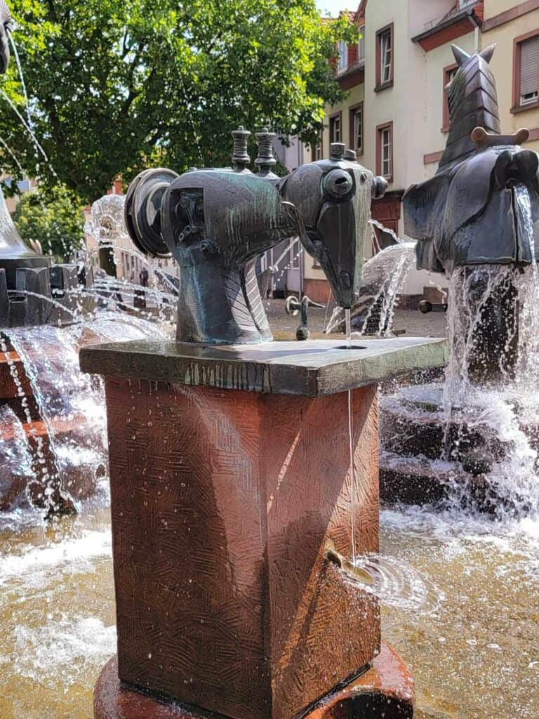 A Pfaff sewing maching with eyes on a pedestal in a fountain