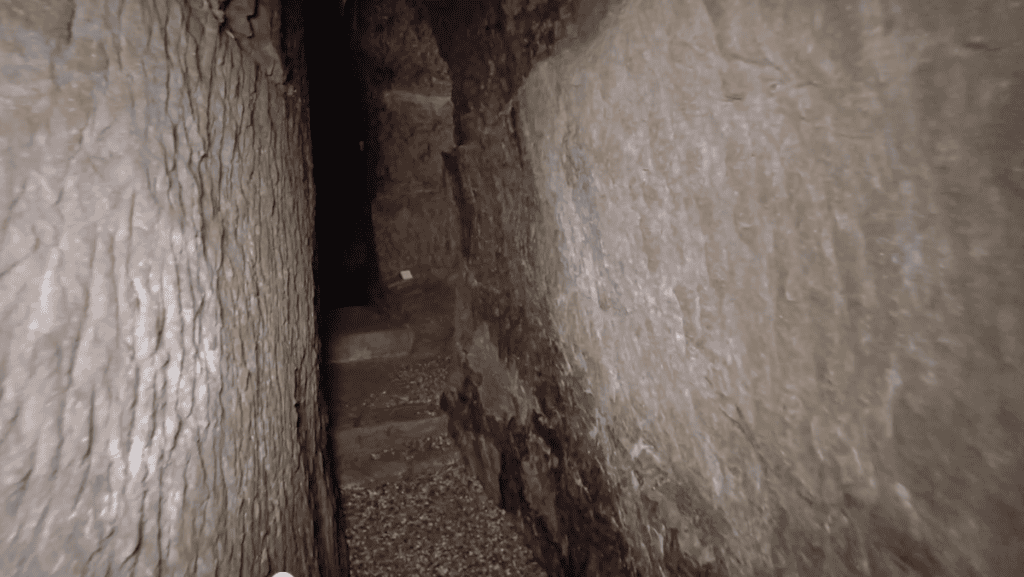 A very narrow passageway with stone walls on either side