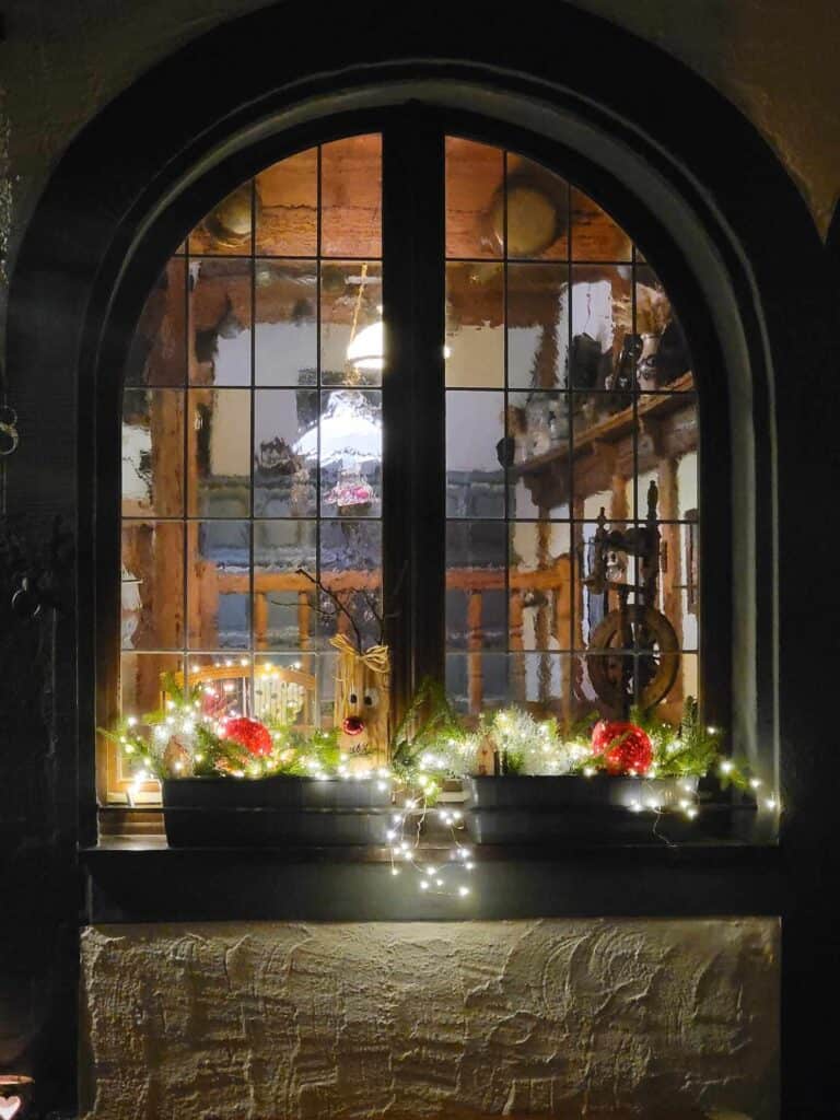 An arched window with festive window boxes