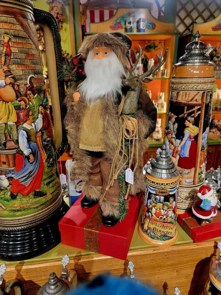 A large Santa dressed as a woodsman in a display of decorated German beer steins