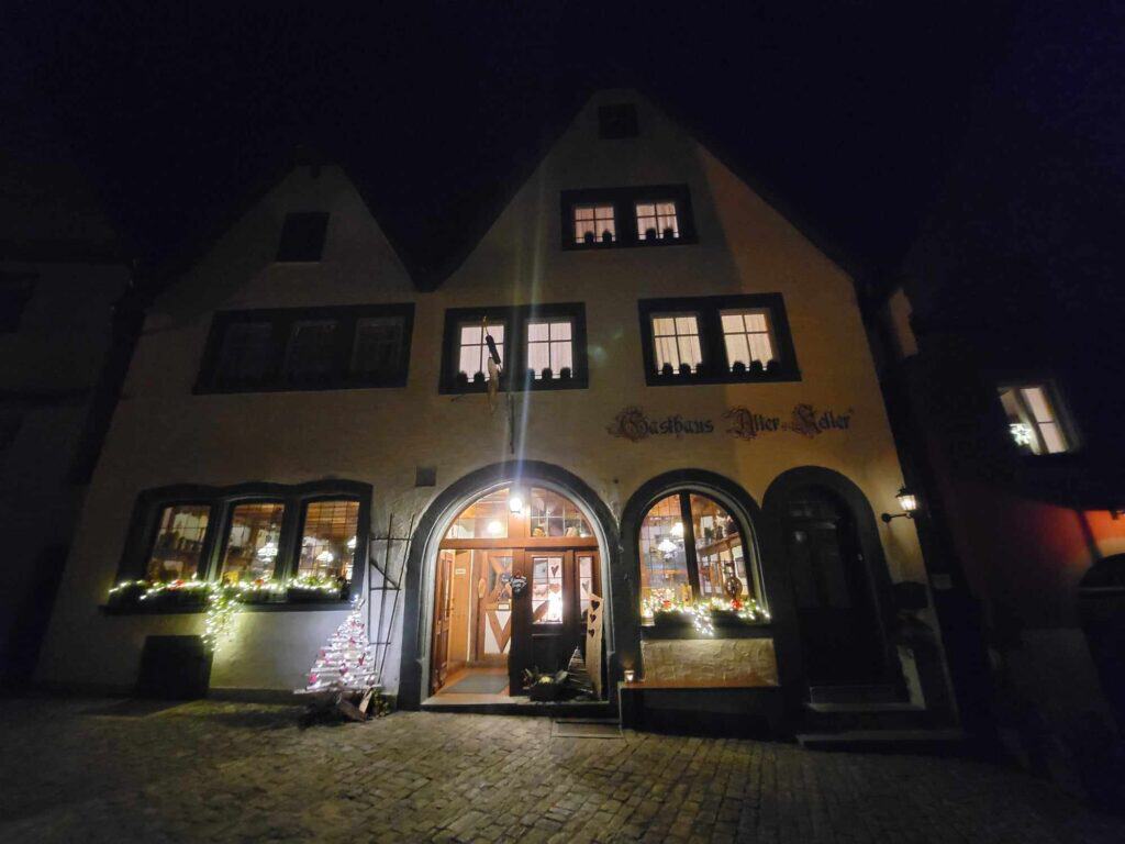 A cozy looking restaurant with a rounded arched doorway and windows