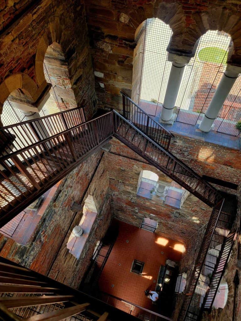 An open tower looking from the top down on a square 3-story staircase