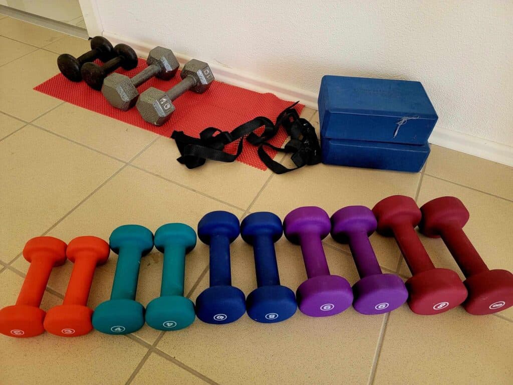 A series of multicolored hand weights on the floor