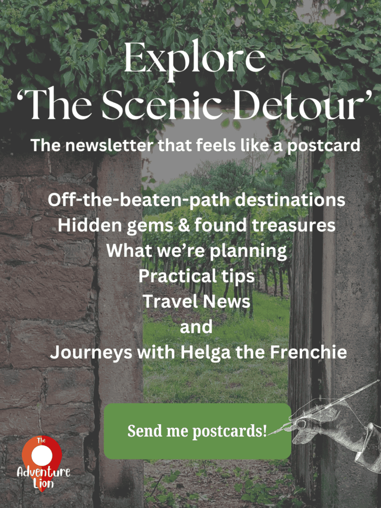 An old stone wall with an arched passage door giving a glimpse of a green vineyard. Copy reads: "Explore 'The Scenic Detour' the newsletter that feels like a postcard. Off-the-beaten-path destinations Hidden gems & found treasures What we’re planning Practical tips Travel News and Journeys with Helga the Frenchie" Then a green button that reads "Send me postcards!"