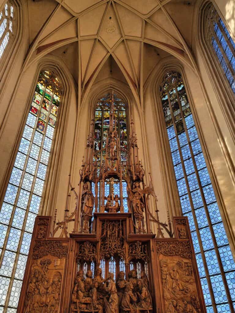 An intricately carved altarpiece with stained glass behind