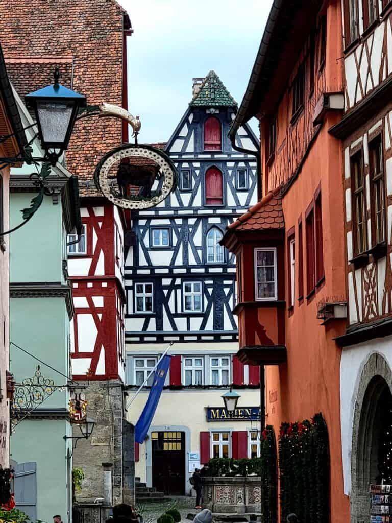 A cluster of timbered houses in red, white, pink, and green