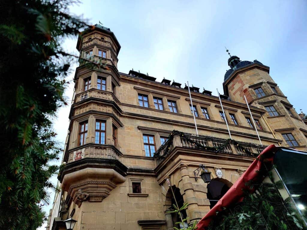 The town hall building with two towers, made of beige stone