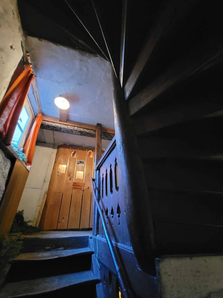 Curved wooden stairs lead to a door