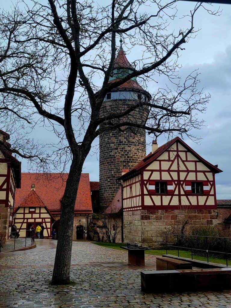 The tall round Sinwell tower with timbered buildings in the castle complex