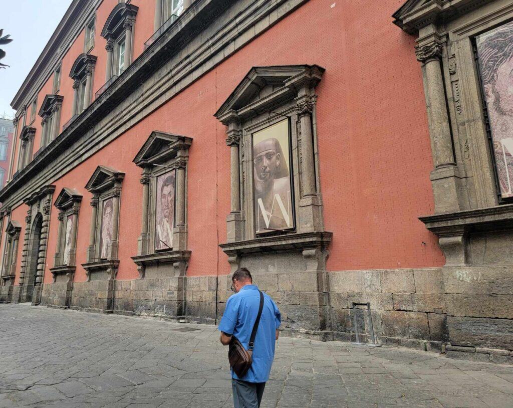 Pompeii vs. Herculaneum: Best Tips & Biggest Differences 22 A man walking in front of the Archaeological Museum in Naples