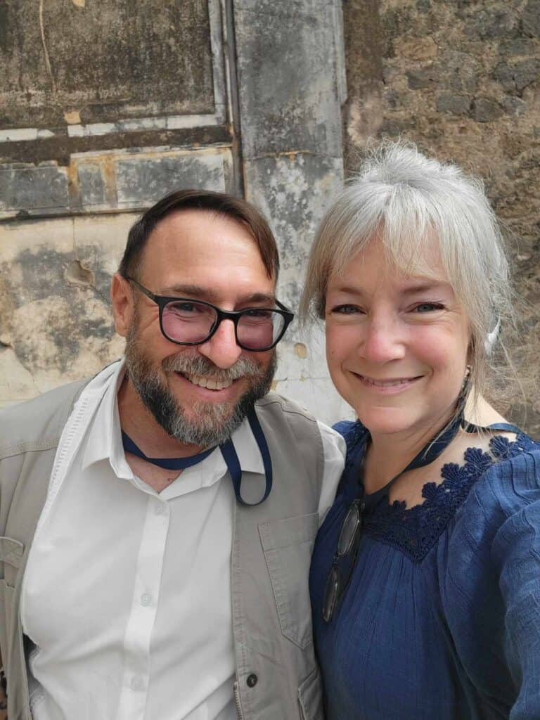 Pompeii vs. Herculaneum: Best Tips & Biggest Differences 34 A smiling couple in front of a stone wall in Pompeii