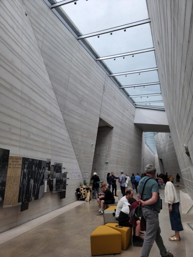 Best 2 Day Dordogne Prehistory Itinerary: What to See & Do 18 A very modern, tall gallery inside the Lascaux museum with skylights above and people looking at exhibits