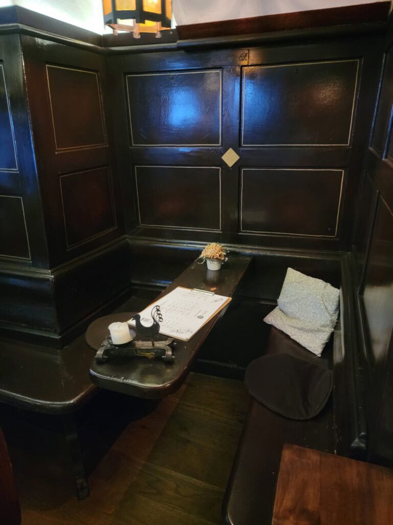 One Day in Bacharach: Best Guide to Germany's Hidden Gem on the Rhine 17 A dark wood restaurant booth with a thin long table for wine glasses