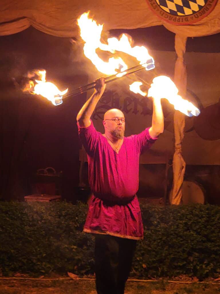 One Day in Bacharach: Best Guide to Germany's Hidden Gem on the Rhine 30 A man in a red tunic and black pants twirling four sets of fire sticks