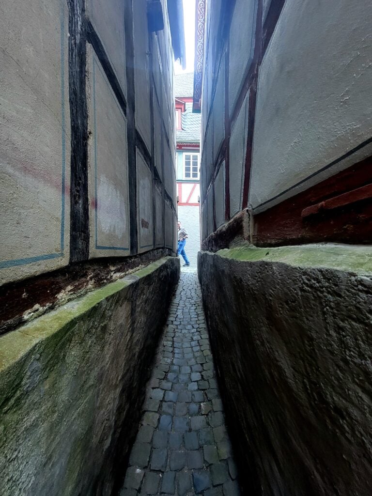 One Day in Bacharach: Best Guide to Germany's Hidden Gem on the Rhine 20 A very very thin alleyway between two half timbered buildings, and a man walking across the field of view on the far end