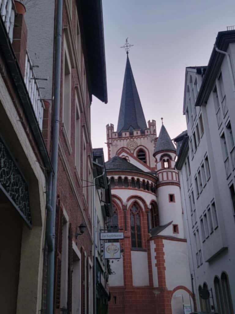 One Day in Bacharach: Best Guide to Germany's Hidden Gem on the Rhine 5 A white medieval church with red sandstone details and two tall towers