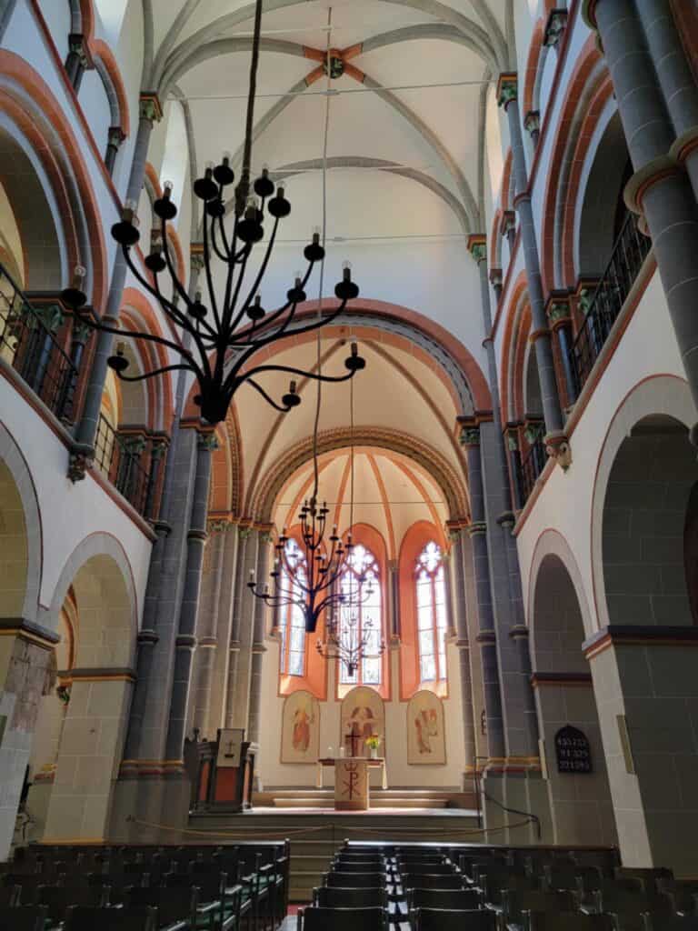 One Day in Bacharach: Best Guide to Germany's Hidden Gem on the Rhine 6 The inside of the church with white trimmed in pinkish sandstone and a large iron chandelier