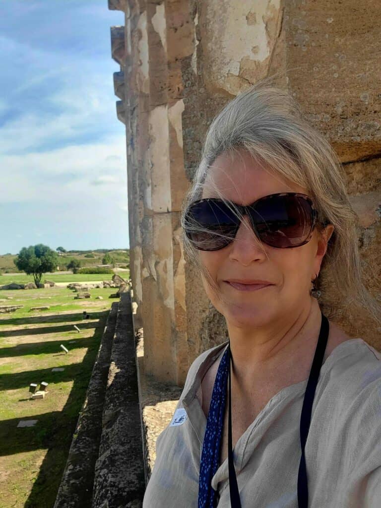 A happy woman standing in the Temple of Hera at Selinunte Archaeological Park in Sicily