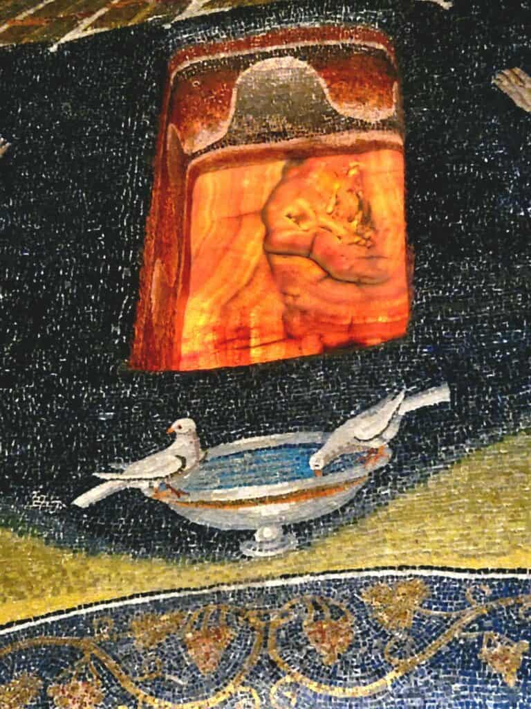 An alabaster window and mosaic of birds and grapes in the Mausoleum of Galla Placidia in Ravenna Italy