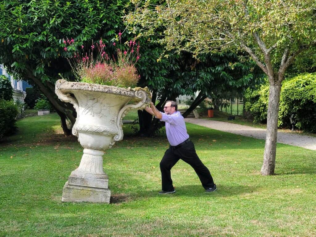 A man and an urn at the Waldorf Astoria Trianon Palace Versailles garden