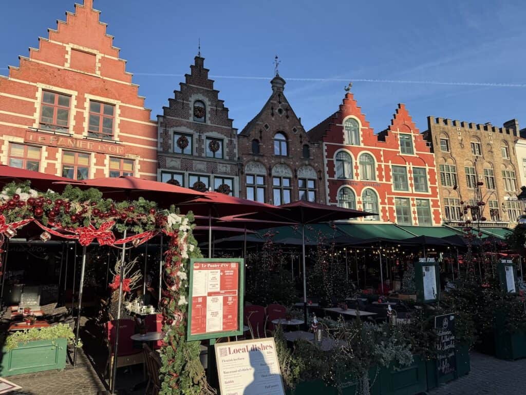 Bruges Christmas Market 2026: Winter Glow, Waffles & an Actual Michelangelo 4 Christmas stalls and beautiful brick buildings in Bruges Christmas market